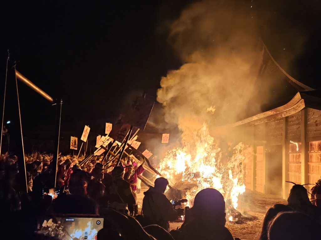 2026年太宰府天満宮鬼すべ神事。点火の瞬間。氏子たちが鬼すべ堂に向かって火をあおっている様子。