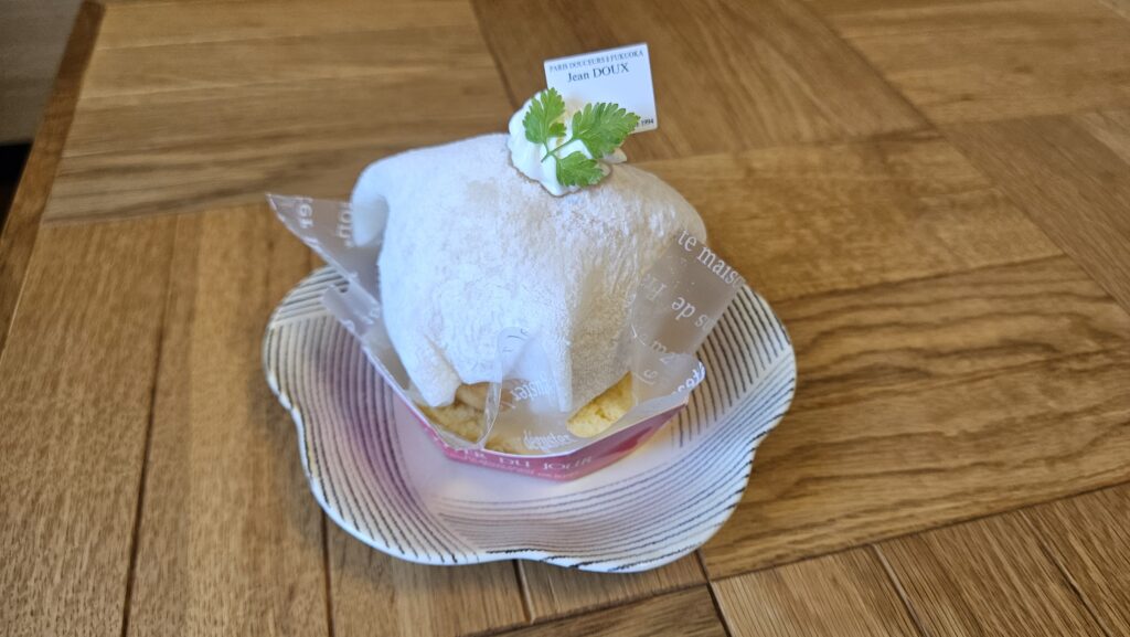 大宰府の有名菓子店「ジャンドゥ」の期間限定・数量限定の桃スイーツである「桃の夏かご」の外観。
しっとりとした求肥にくるまれた大きな桃のケーキが皿の上にのっている写真