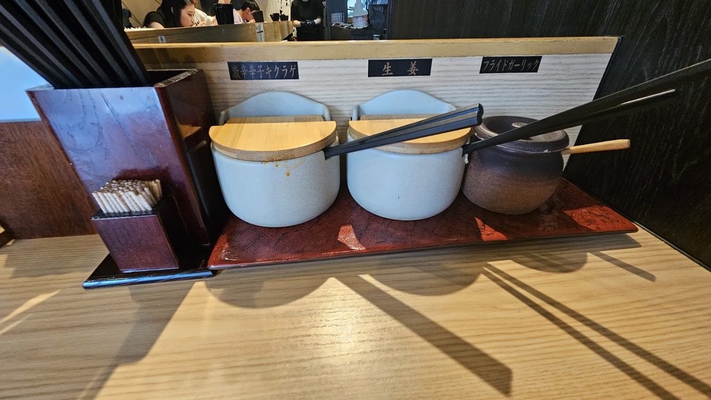 太宰府天満宮近くのラーメン店「おいげん」の卓上調味料。激辛辛子きくらげ、生姜、フライドオニオンが入ったツボがある