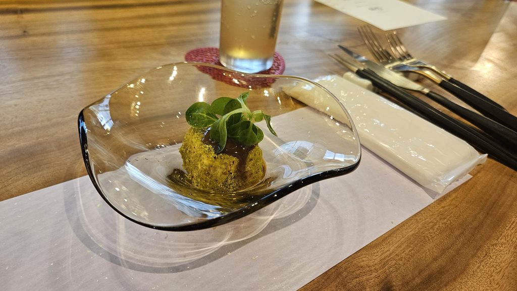 筑紫野市にあるレストラン「田丸別館」の前菜「ピスタチオ豆腐」がテーブルに乗っている様子